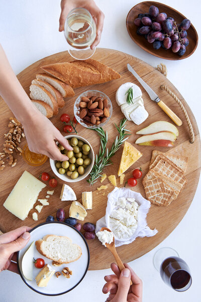Cheese board with hands, party snacks