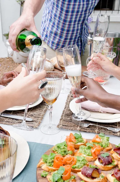 Champagne flöjter och rosta bland vänner — Stockfoto