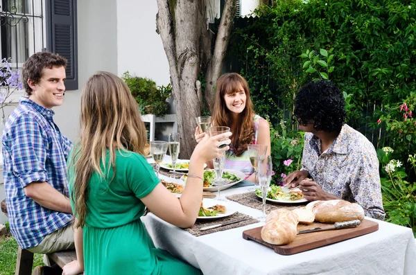 Amigos em uma festa ao ar livre no jardim com alimentos e bebidas — Fotografia de Stock