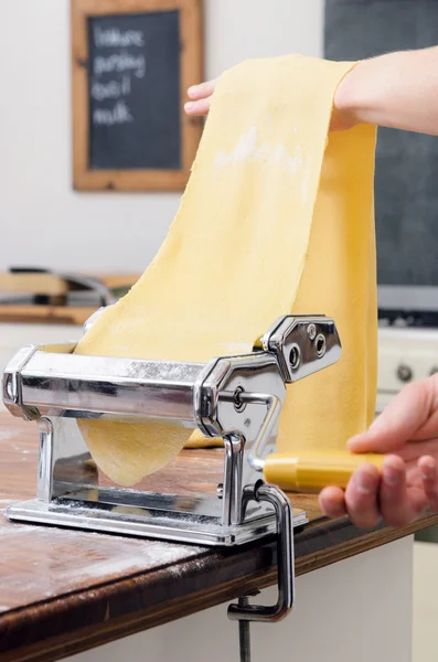 Rolling masa cruda a través de la máquina de pasta — Foto de Stock