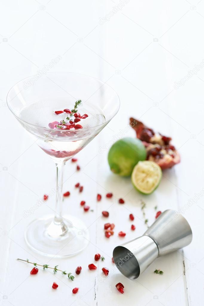 Martini cocktail with lime and pomegranate pips