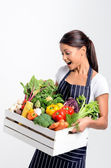 Usměvavý kuchař s zástěru drží organické produkty