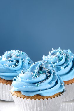 Blue cupcakes with silver decorations clipart