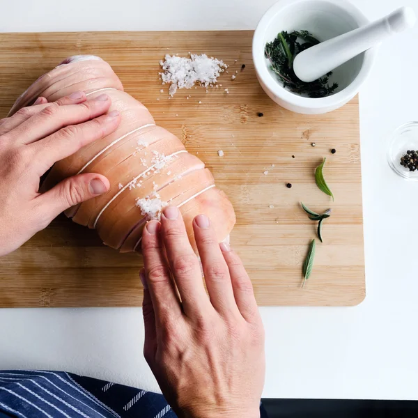 Chef-kok handen kruiden in een stuk vlees — Stockfoto