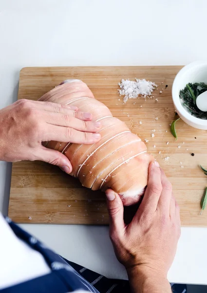 Chef-kok handen kruiden in een stuk vlees — Stockfoto