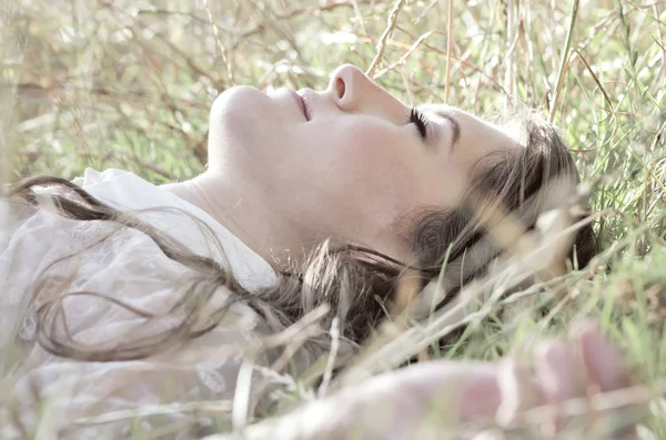 Kız çimenlerde yatıyor. — Stok fotoğraf