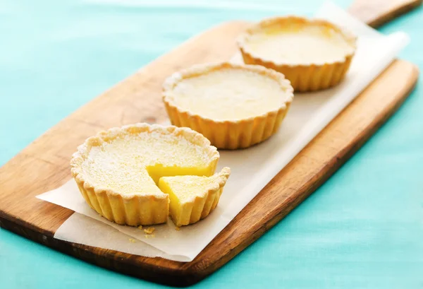 Lemon tarts on a wooden serving board — Stock Photo, Image