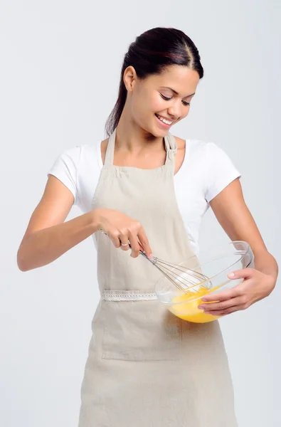 Счастливая улыбающаяся женщина бьет яйца — стоковое фото