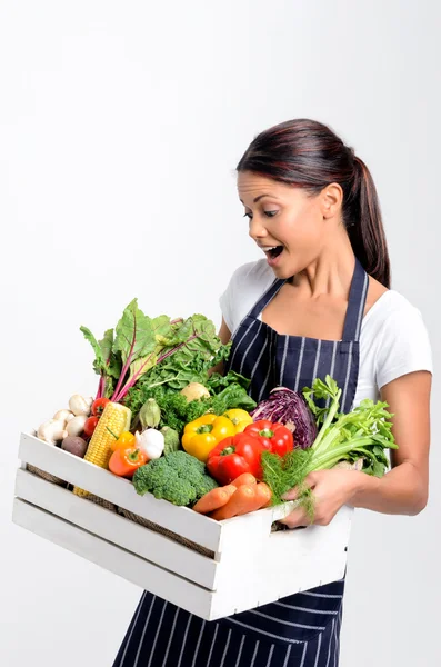 Chef sorridente com avental segurando produtos orgânicos — Fotografia de Stock