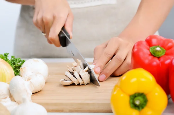 Hands holding knife cutting vegetables — Stock Photo, Image