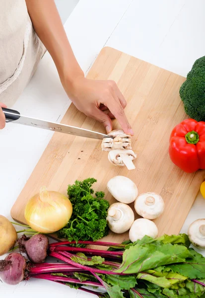 Руки держат нож режет овощи — стоковое фото