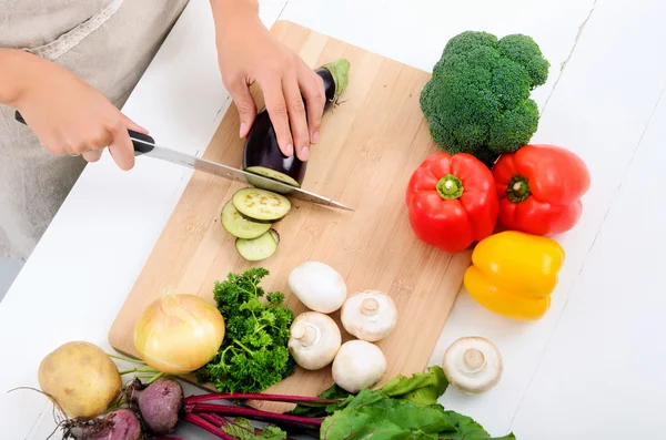 Hands holding knife cutting vegetables — Stock Photo, Image