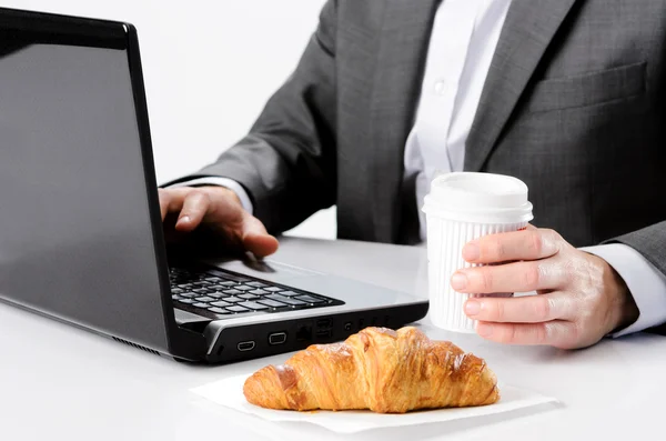 Man in suit works while having breakfast — Stock Photo, Image