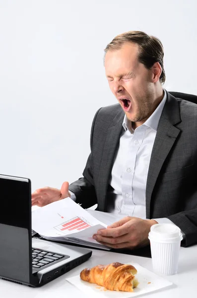 Hombre de negocios trabajando incansablemente en su escritorio — Foto de Stock