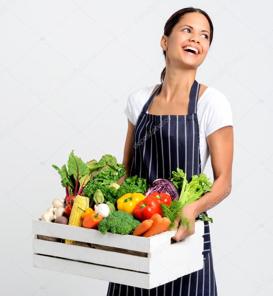 Smiling chef with apron holding organic produce