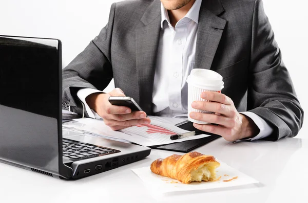 Business man types on smartphone while having a breakfast — Stock Photo, Image