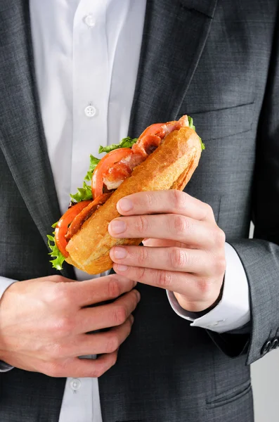 ランチのサンドイッチを保持しているスーツの男 — ストック写真