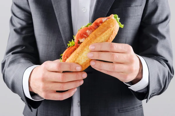 Бизнесмен держит булочку с обедом — стоковое фото