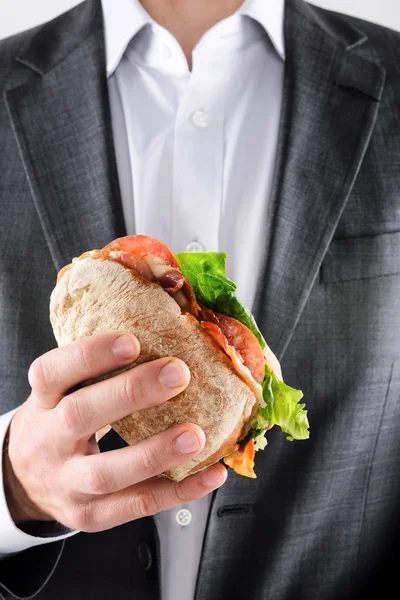 Hombre de traje sosteniendo sándwich de almuerzo —  Fotos de Stock