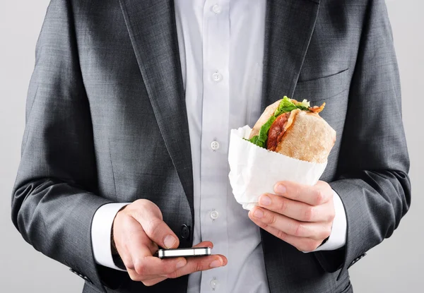 Man in suit sending sms while getting lunch — Stock Photo, Image