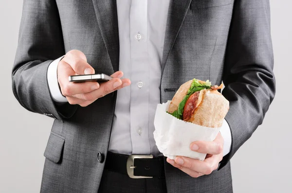 Empresário trabalhando enquanto almoça — Fotografia de Stock