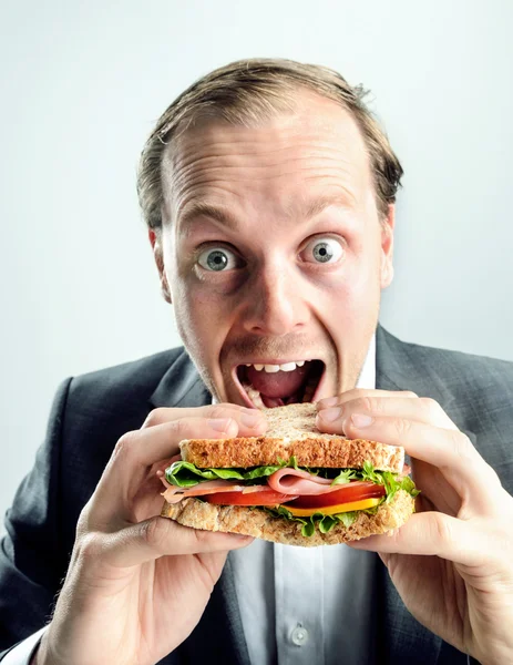 Grappige bedrijf man eten sandwich — Stockfoto