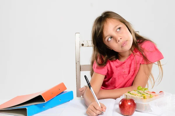 Junges Mädchen macht ihre Hausaufgaben auf dem Tisch — Stockfoto