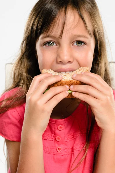 Escola menina comendo seu lanche embalado sanduíche — Fotografia de Stock