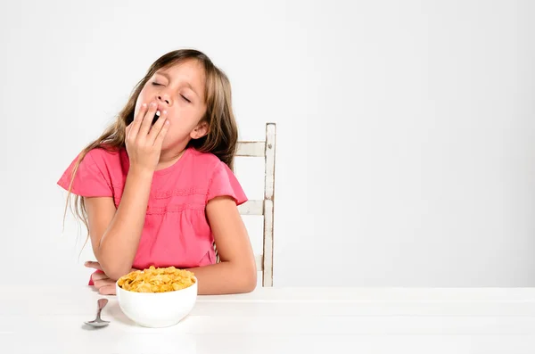 Trött barn med skål med frukostflingor — Stockfoto
