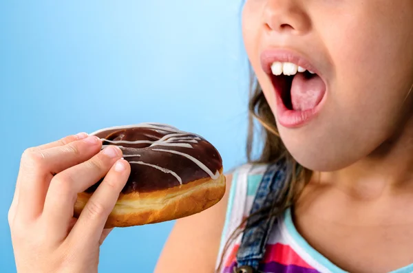 Glückliches Kind isst einen Donuts — Stockfoto