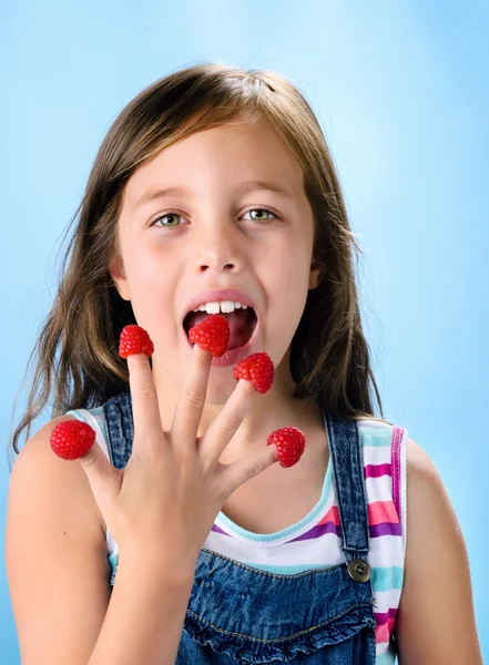 Young child eating raspberries — Stock Photo, Image