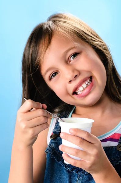 Felice giovane ragazza mangiare yogurt probiotico — Foto Stock