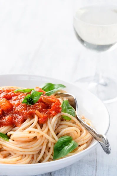 Spaghetti with red tomato sauce and basil garnish