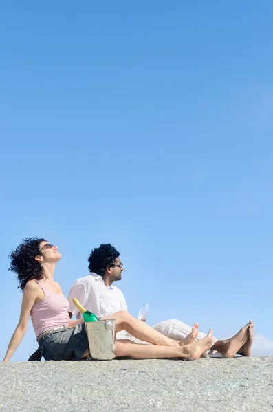 Couple enjoying themselves by the sea with champagne sparking wi — Stock Photo, Image