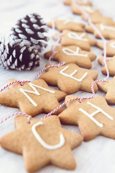 Christmas ginger cookies iced with 'merry christmas' tied — Stock Photo, Image