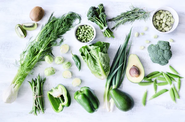 Groene groenten op witte rustieke achtergrond — Stockfoto