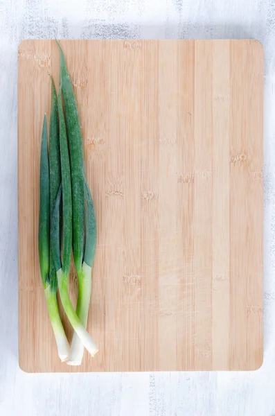 Spring onion on wooden board — Stock Photo, Image