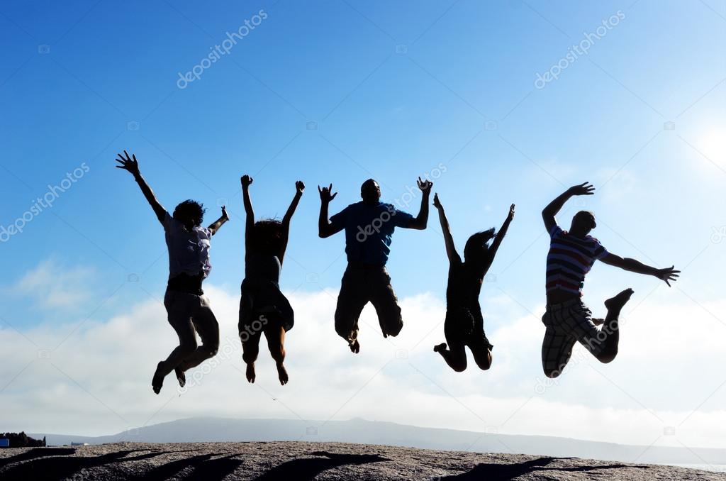 group of friends jumping outdoors