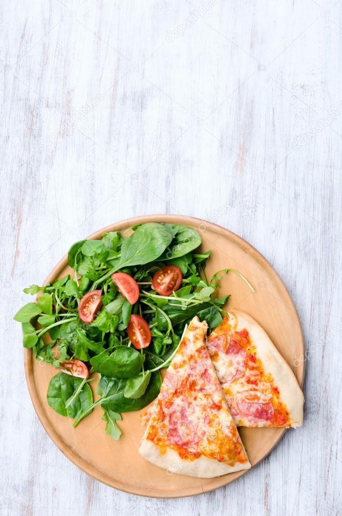 Pizza with salad dinner on rustic background