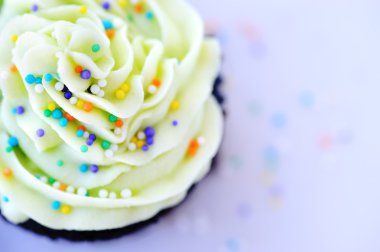 Chocolate cupcake with plenty of sprinkles clipart