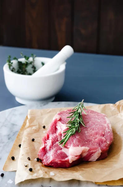 Première coupe de boeuf cru sur papier de boucherie — Photo