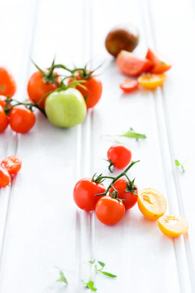 Pomodori su sfondo rustico con foglie — Foto Stock