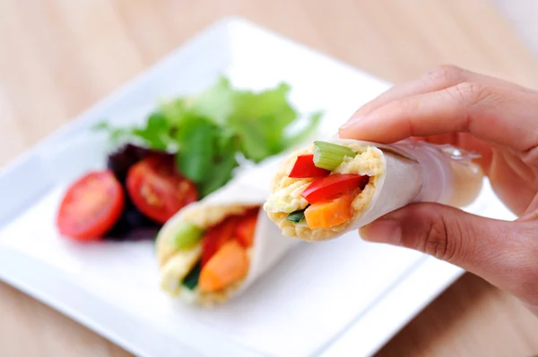 Hand som håller ett hälsosamt mellanmål wrap — Stockfoto