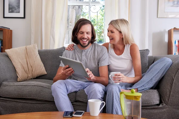 Couple with tablet and mugs — Stock Photo, Image