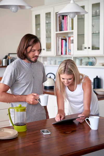 Pareja con tablet ordenador en la cocina — Foto de Stock