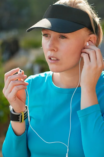 Sporty woman listening music on earphones — Stock Photo, Image