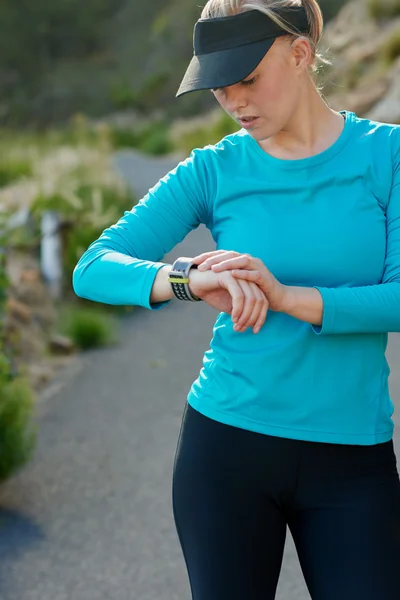 Mujer caucásica de comprobar el tiempo durante un entrenamiento de correr —  Fotos de Stock