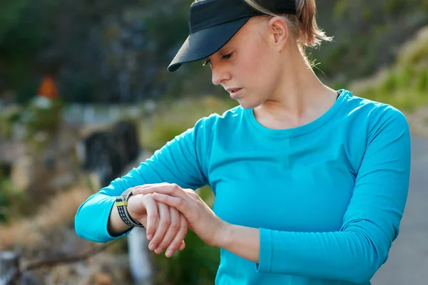 Mujer caucásica de comprobar el tiempo durante un entrenamiento de correr —  Fotos de Stock