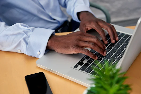 Homme tapant sur ordinateur portable au bureau — Photo