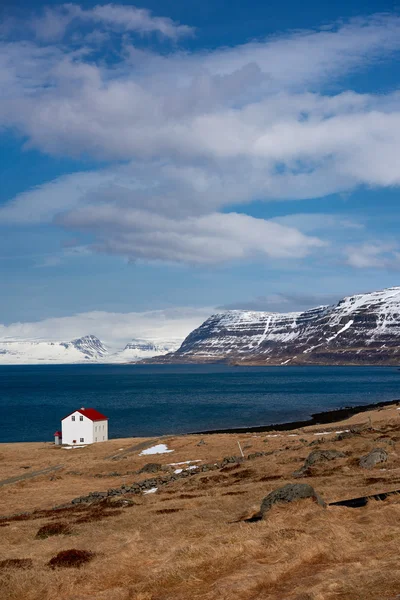 Cabine perto do lago e nevado fiordes ocidentais em montanhas icelândicas — Fotografia de Stock